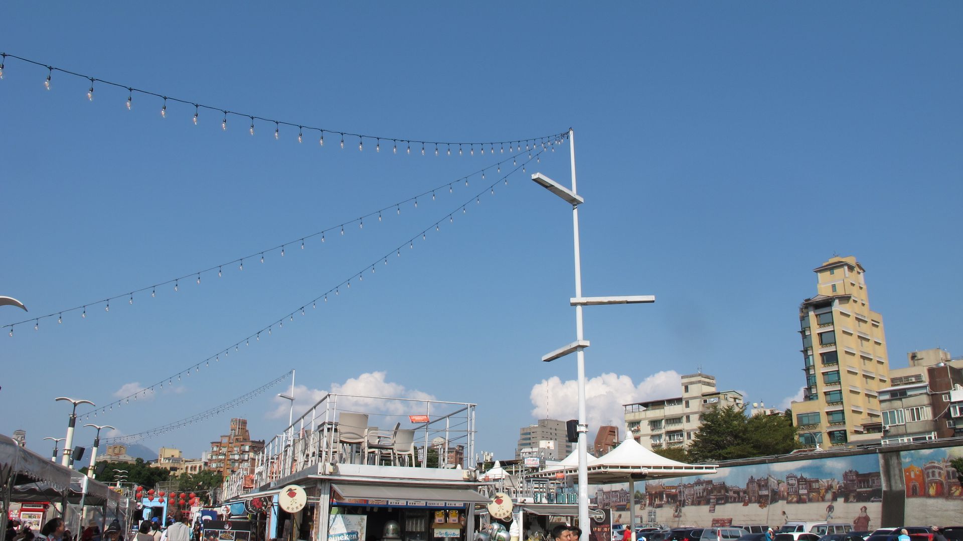 Vibrant street market scene in Dadaocheng with clear blue skies and bustling activity.