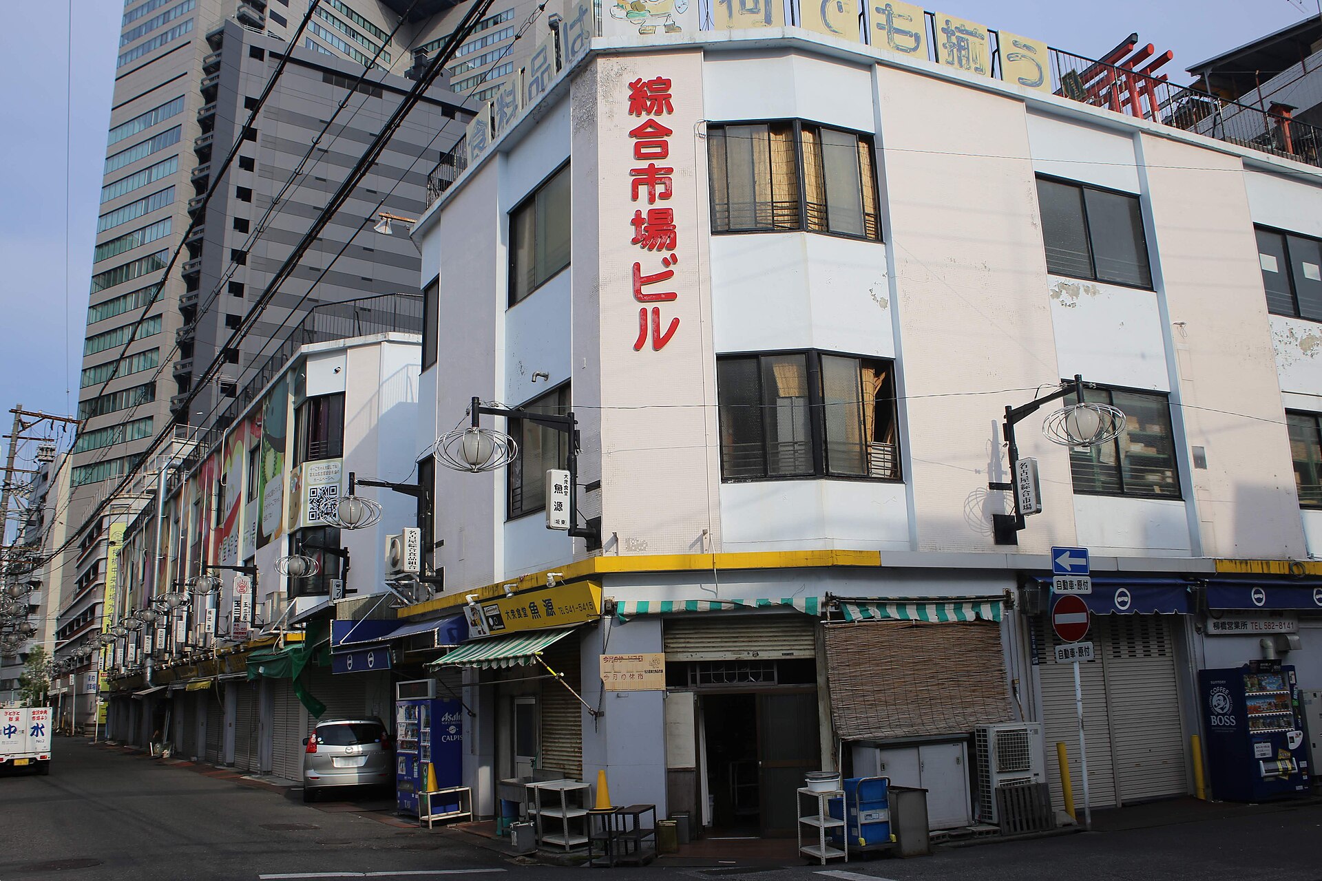 白色市场楼的转角挂着红字「総合市場ビル」，楼顶写着「柳橋中央市場」，一层卷帘门多半关着