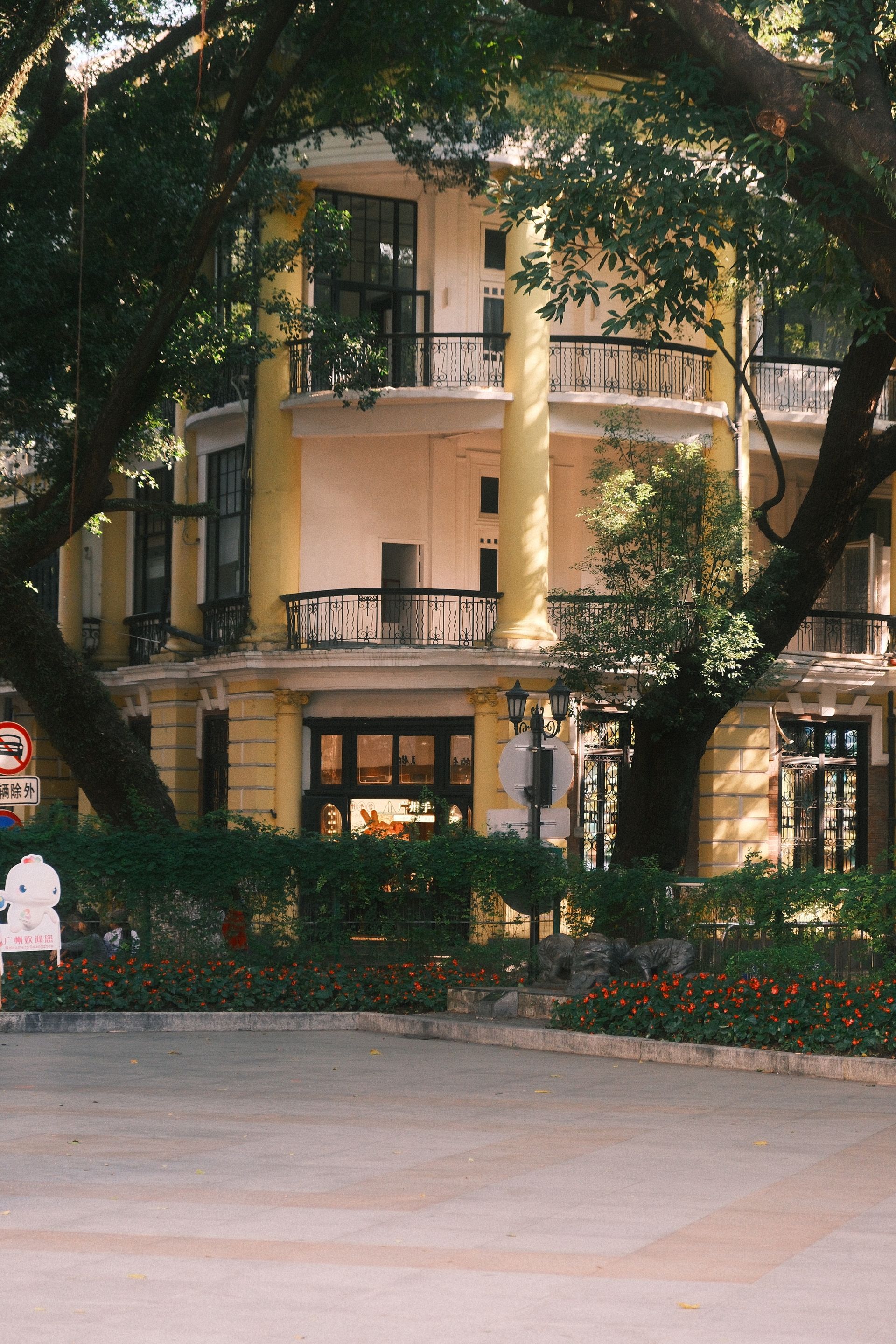 Charming yellow colonial building surrounded by trees on Shamian Island, Guangzhou, China.