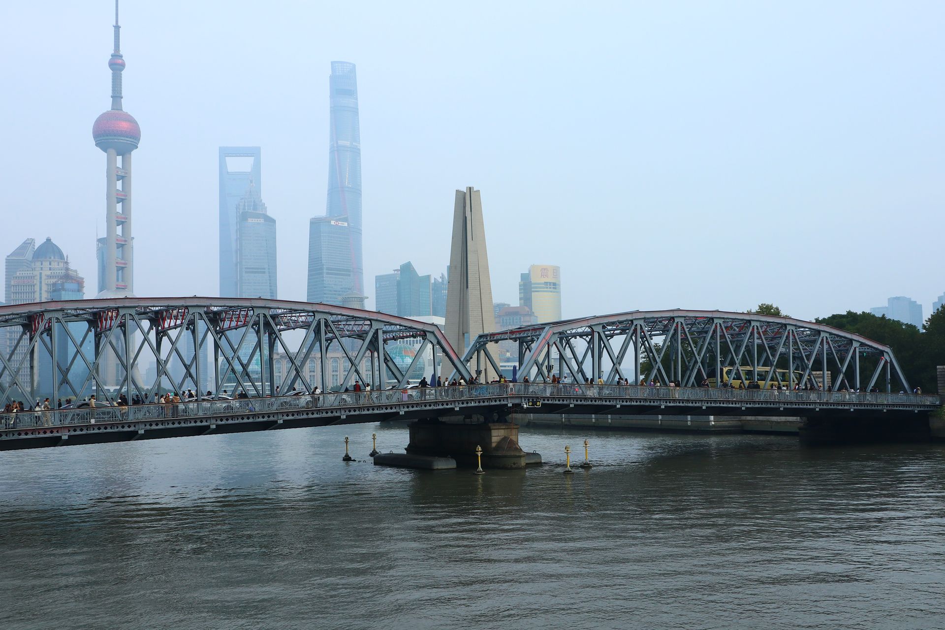 View of Waibaidu Bridge and Shanghai skyline on a clear day with iconic skyscrapers in background.