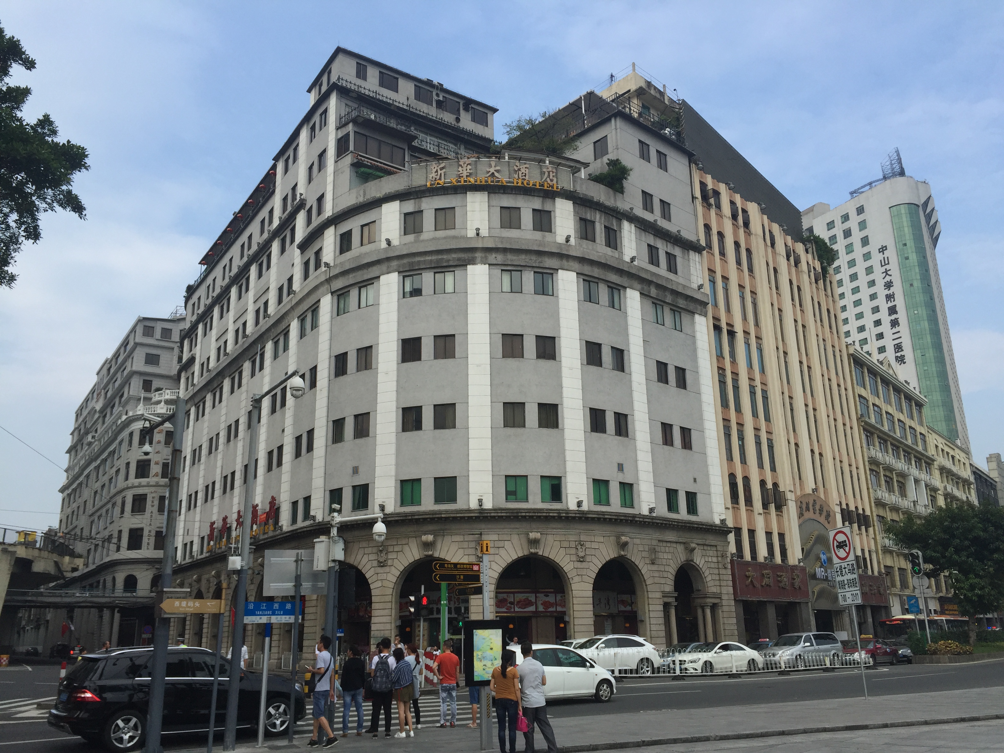 广州人民南路与沿江西路路口的骑楼街景，可见「新华大酒店」招牌与「沿江西路」路牌