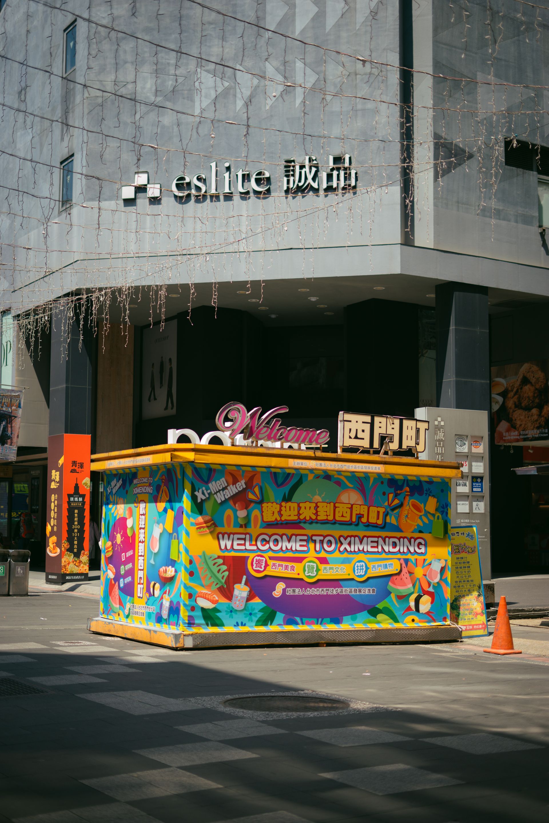 Vibrant kiosk in Ximending, Taipei's bustling shopping district, on a sunny day.