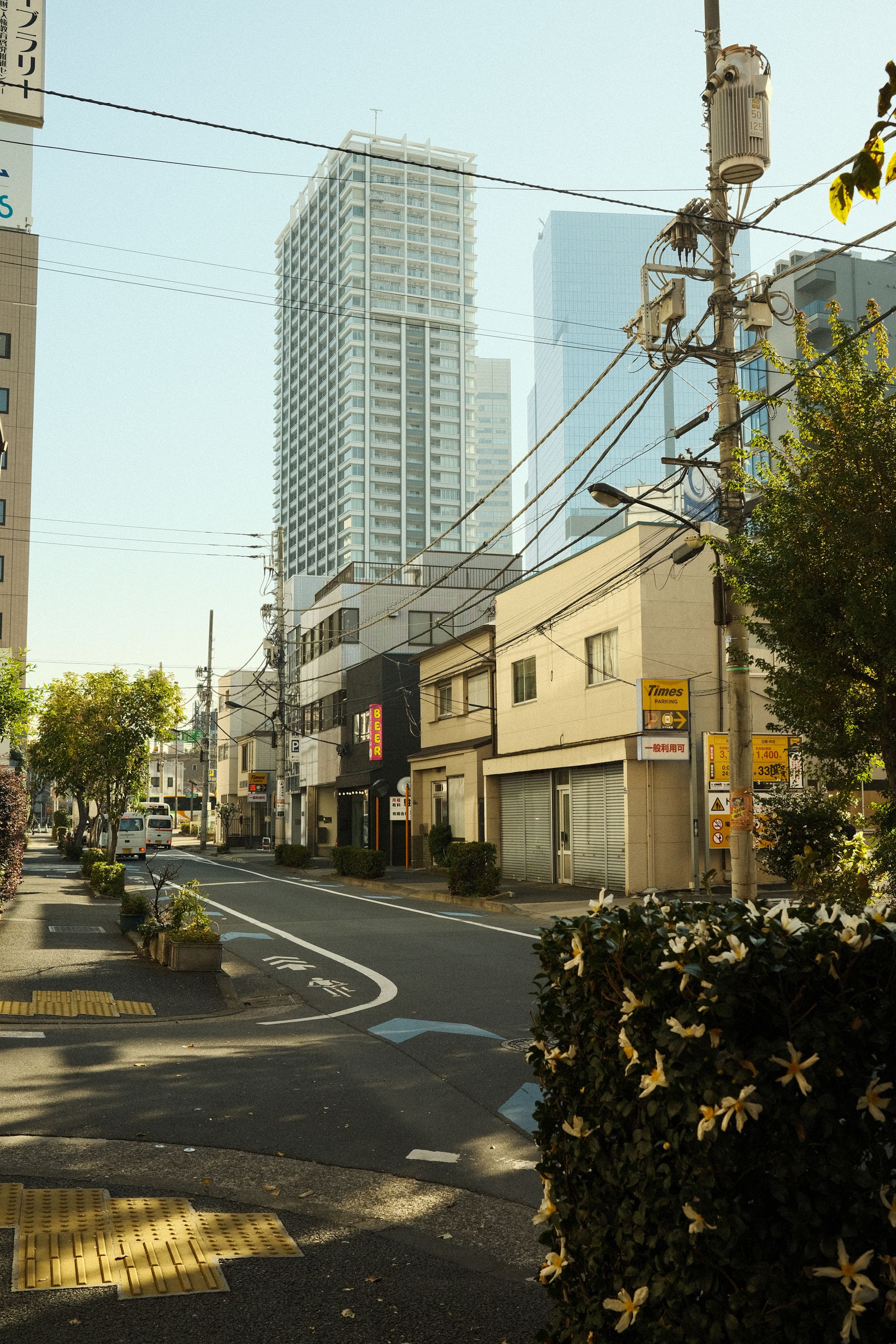 Street view showcasing urban architecture and modern high-rises in a sunny setting.
