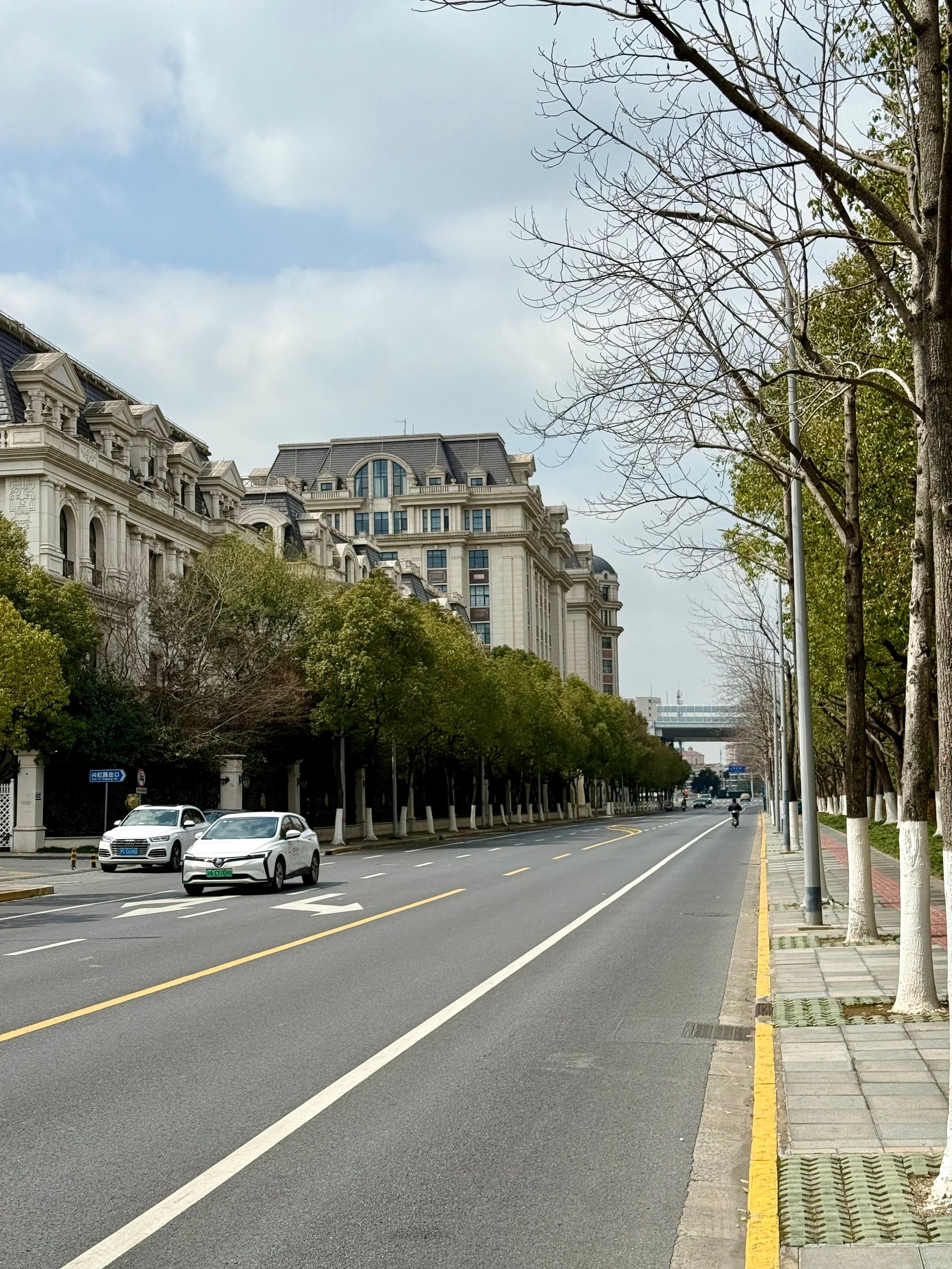 Elegant Parisian-style architecture along a tree-lined street in Shanghai, China.
