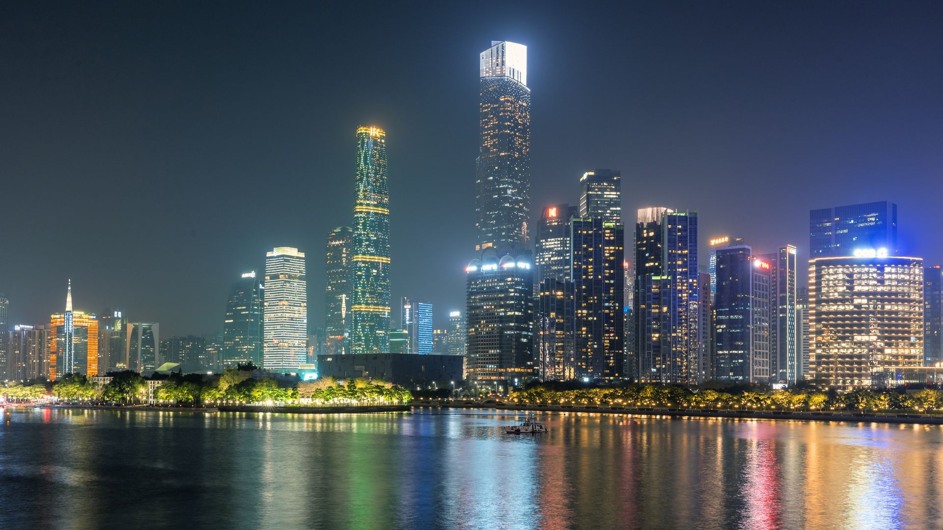 夜色中珠江对岸的摩天楼群与江面倒影