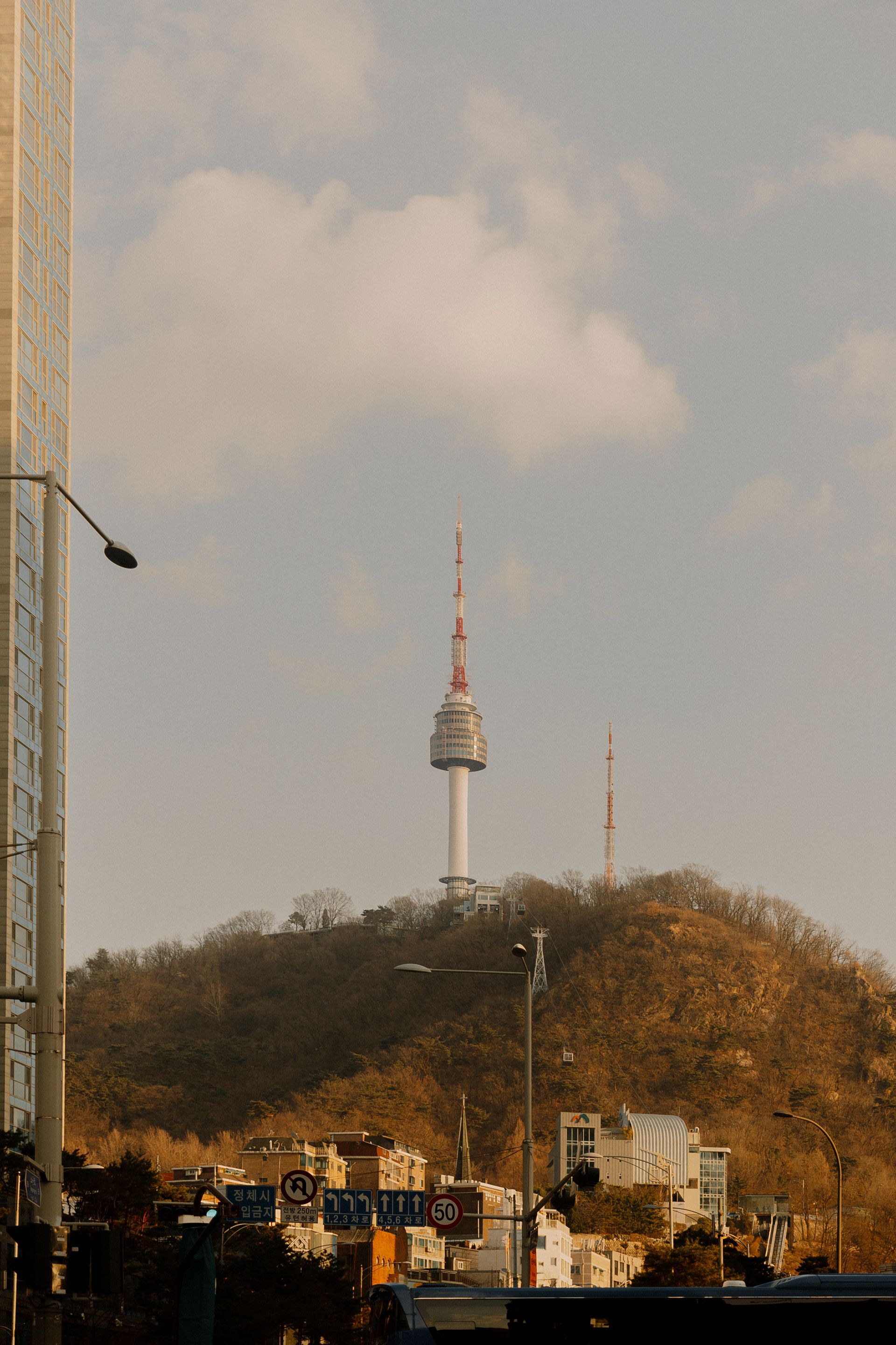 Namsan Tower stands tall on a hill in Seoul with a clear sky backdrop.