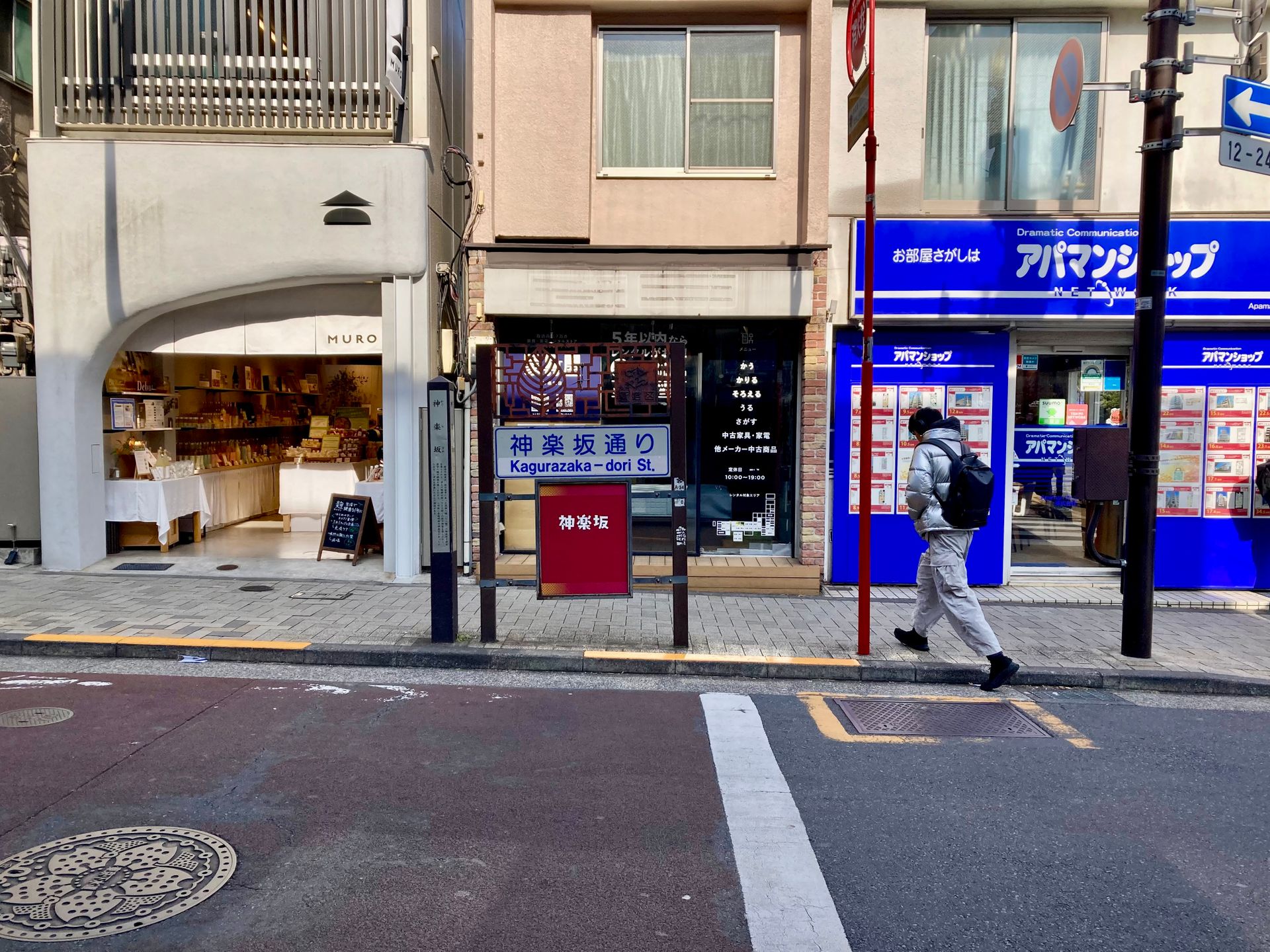 A man walking past shops on Kagurazaka-dori Street in Tokyo, Japan.