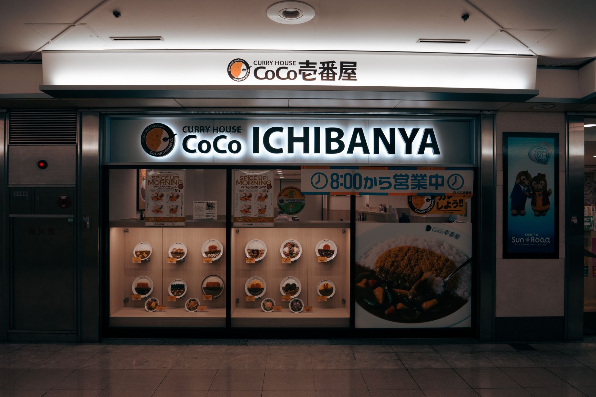 地下街中一家咖喱店的橱窗与食品模型，灯箱招牌亮着