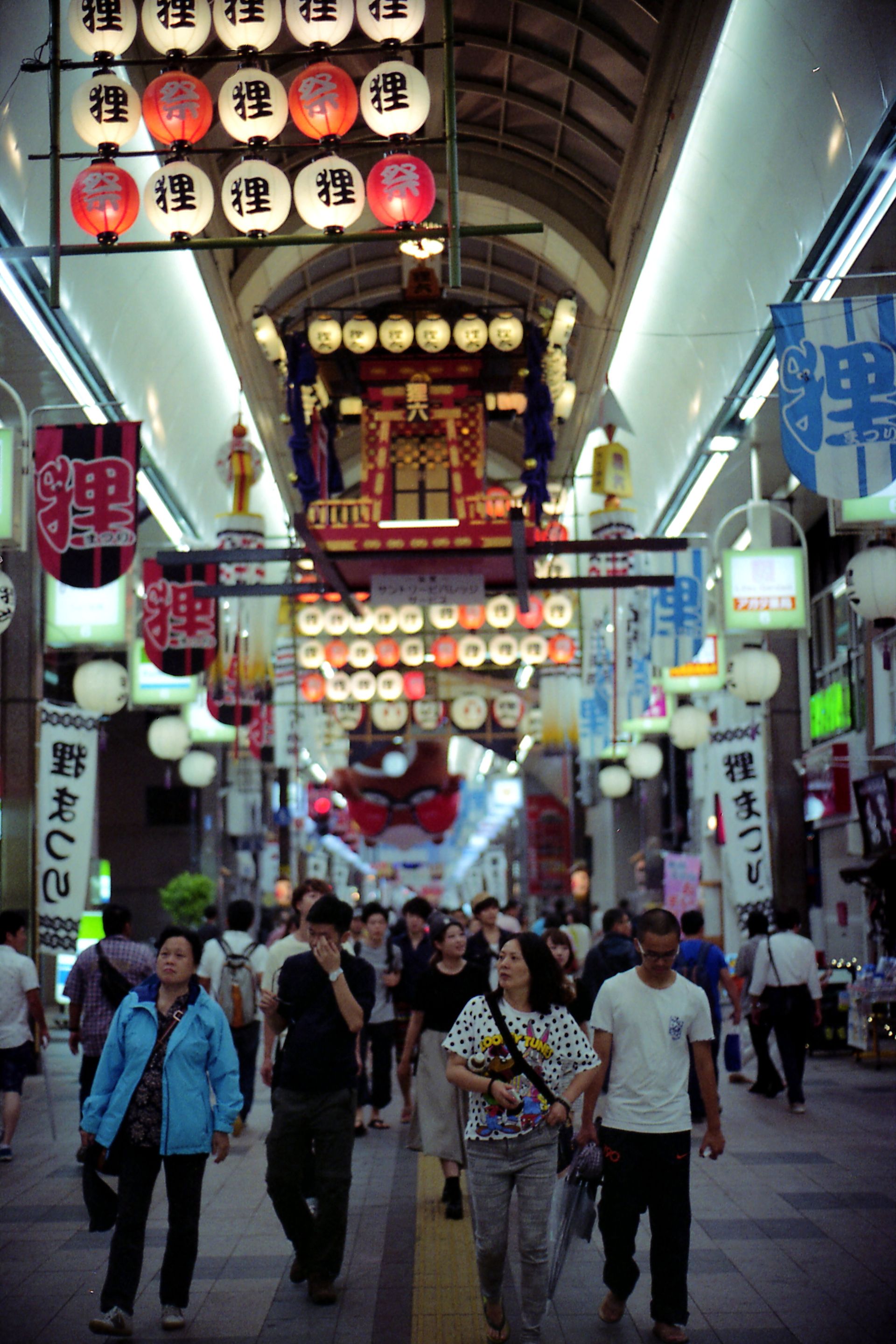 Crowds enjoy the vibrant atmosphere of Tanukikoji Shopping Street in Sapporo, Hokkaido. Explore the lively scene.