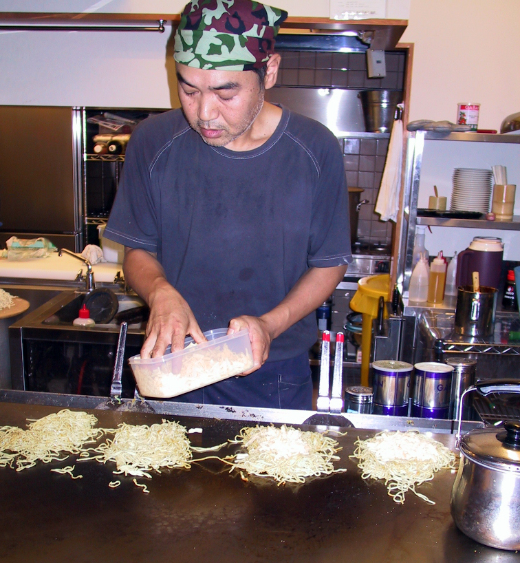 A man prepares Okonomiyaki in a restaurant in Hiroshima, Japan.